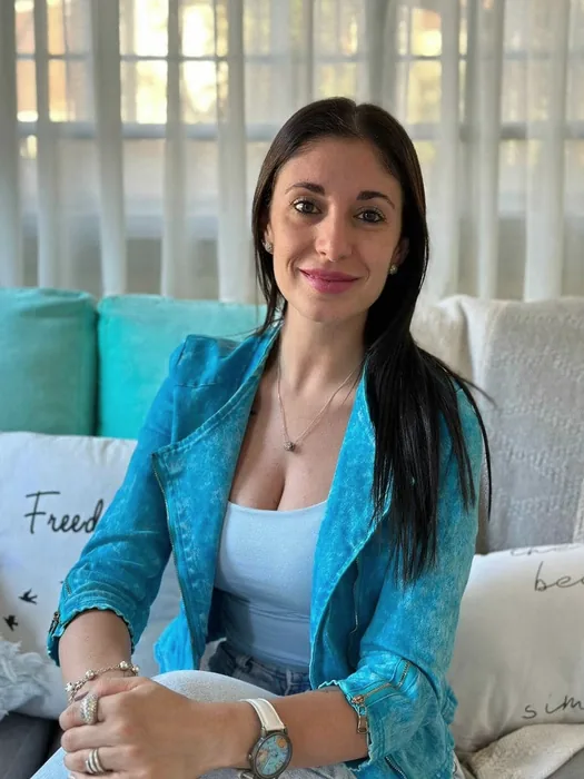 Ornella Toulouse, consteladora familiar, sentada y sonriendo